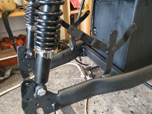 Die Aufnahme für die neuen Federbeine mit unterer Gummibuchse. Die zusätzlich angeschweißten Halterungen sind für das Schutz"blech". Das war bisher nur an den Seitenabdeckungen angebracht mit der Folge, dass einige Laschen durch das starke Geschüttel dort abgebrochen sind.