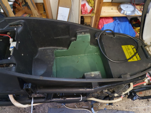 Jetzt viel mehr Platz unter der Sitzbank. Das grüne Plastik war unsprünglich eine Regentonne (Polypropylen, gut schweißbar). Das Ladekabel ist jetzt uch besser zugänglich statt des nervigen Gefummels unter der Klappe im Durchstieg.